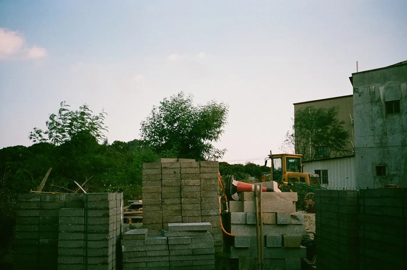 Construction site with stacked concrete blocks and earth-moving machinery